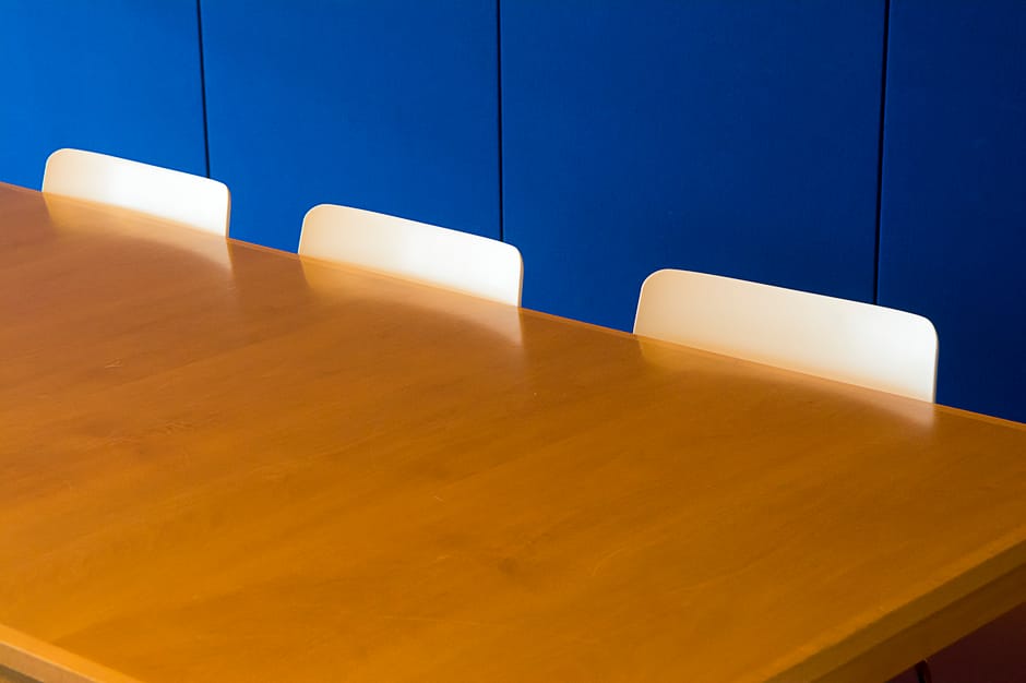 Stijlvolle ronde vergadertafel van hout in moderne kantooromgeving, bevorderlijk voor samenwerking en communicatie.